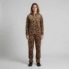 Front view of a woman wearing tan abstract leopard print velour tracksuit.