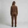 Back view of a woman wearing warm brown leopard print velour tracksuit.