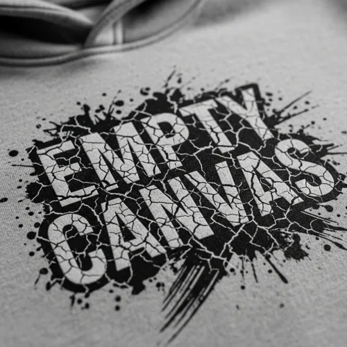 crackle-screen-printed-hoodie-closeup Black and white closeup of a gray hoodie showing the unique, aged, and textured look of crackle screen printing on the "EMPTY CANVAS" design.